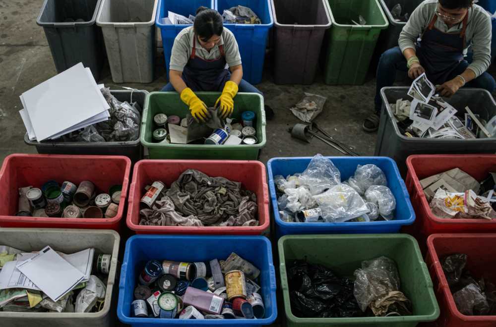Pekerja Digital Printing Sedang Memilah Limbah Tinta, Kertas, Dan Plastik Ke Dalam Tempat Sampah Berlabel Berbeda Sesuai Kategori Limbah.