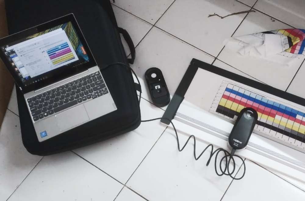 Layar Monitor Sedang Dikalibrasi Dengan Alat Colorimeter, Sementara Tampilan Photoshop Menunjukkan Pengaturan Working Space Srgb Dan Adobe Rgb.