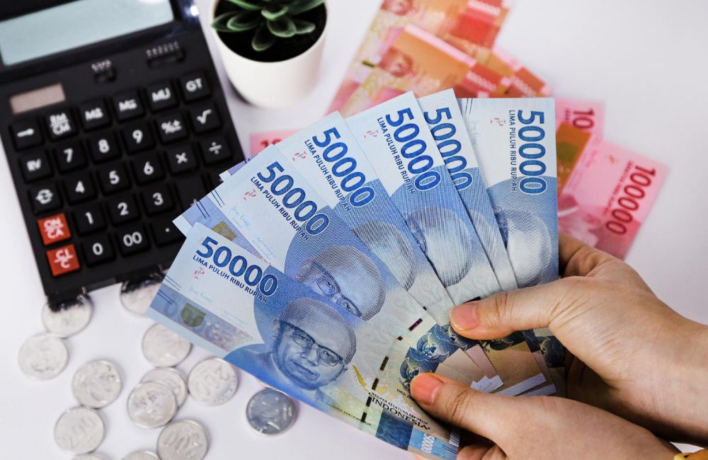 Uang Rupiah Pecahan Lima Puluh Ribu Dan Seratus Ribu Dengan Kalkulator Di Atas Meja.