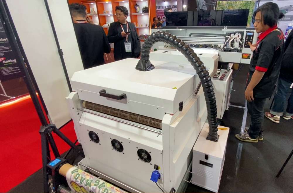 Mesin Dtf Roll-To-Roll Sedang Digunakan Untuk Mencetak Desain Dalam Jumlah Besar Di Pameran Percetakan.