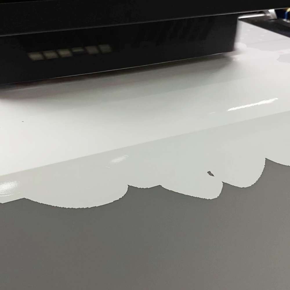 Printer Dtf Sedang Mencetak Lapisan Tinta Putih Di Atas Film Pet Sebagai Dasar Desain.