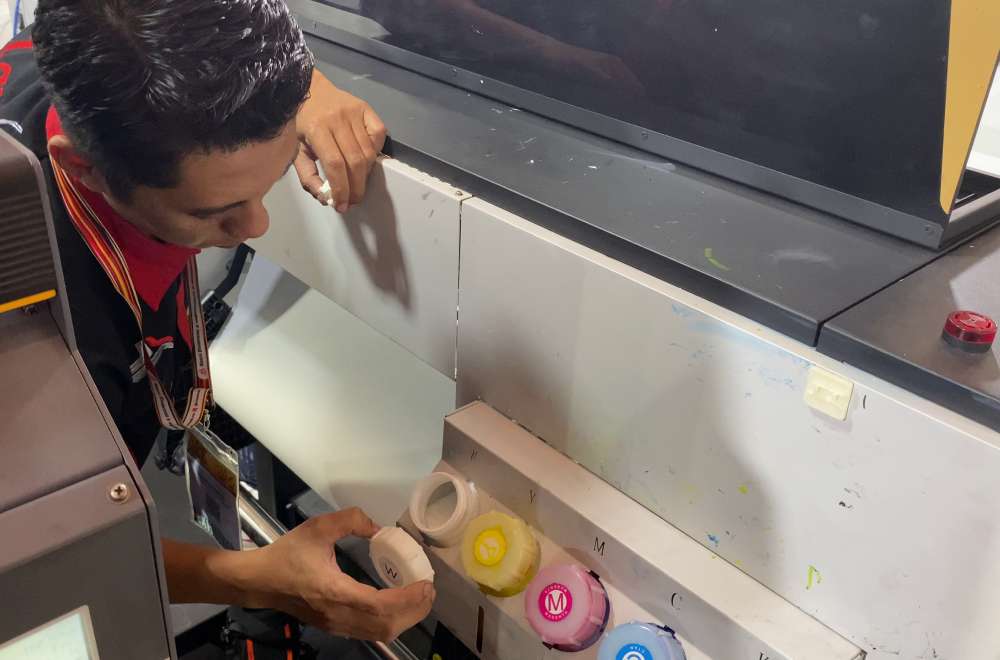 Teknisi Memeriksa Dan Mengganti Tinta Printer Dtf Untuk Memastikan Proses Cetak Berjalan Lancar Dan Efisien.