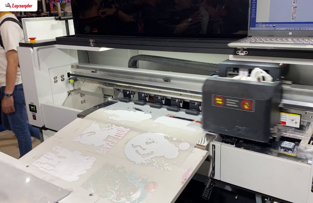 Mesin Dtf Roll-To-Roll Sedang Mencetak Desain Pada Film Pet Dengan Detail Warna Dan Lapisan Tinta Putih