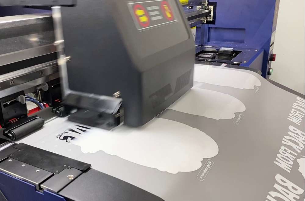 Printer Dtf Sedang Mencetak Desain Berwarna Putih Di Atas Lembaran Pet Film Secara Presisi